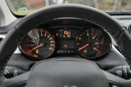 Tableau de bord d'une Peugeot 208 avec plusieurs voyants d'alerte allumés en orange et rouge